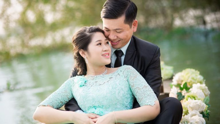 A joyful Asian couple enjoying an engagement moment in a beautiful garden.